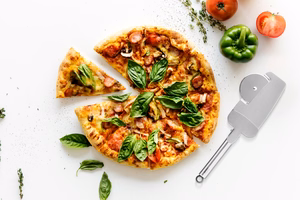 Pizzaleikkuri leikkuupyörällä, reunoja leikkaavilla hampailla ja puristimellisella lastalla