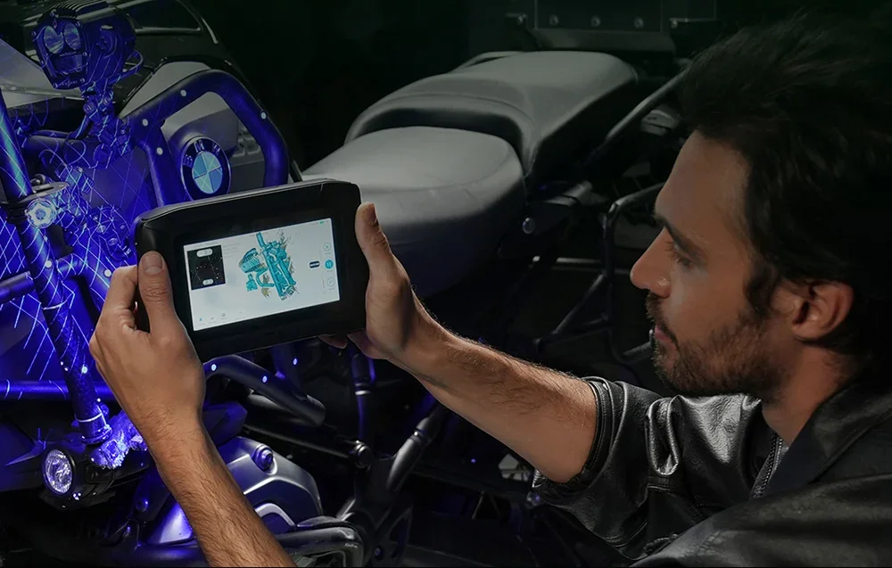 Kädessä pidettävä 3D scanner osoittaa BMW-moottoripyörän moottoriin
