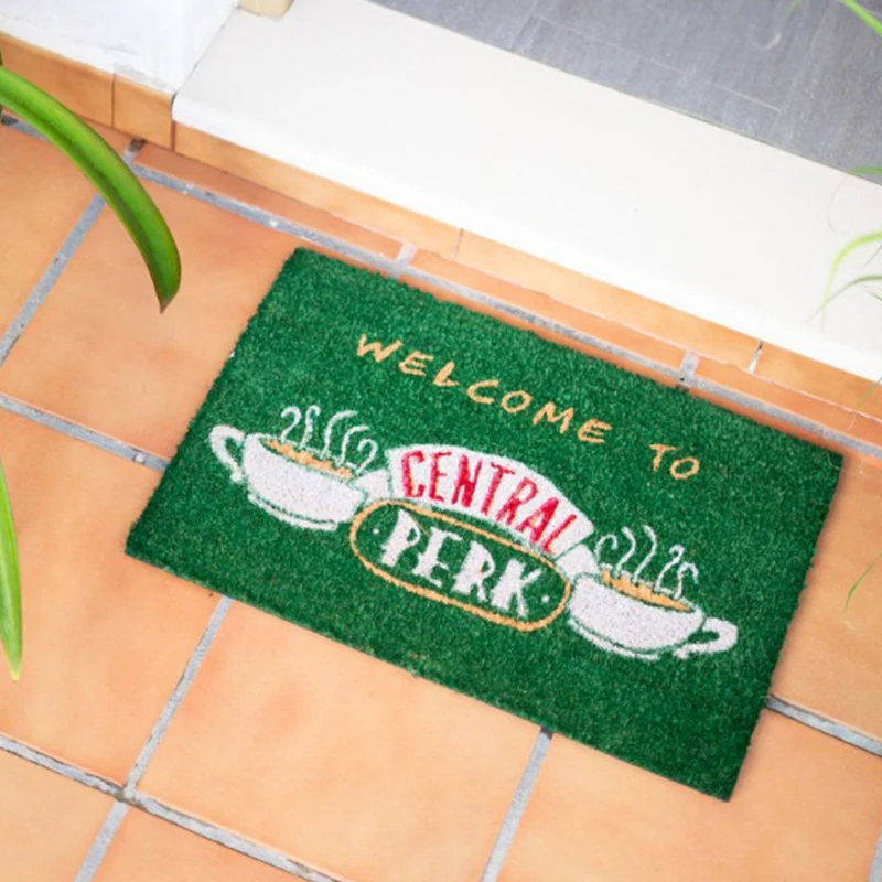 Vihreä Central Perk -ovimatto oviaukon edessä laattalattialla